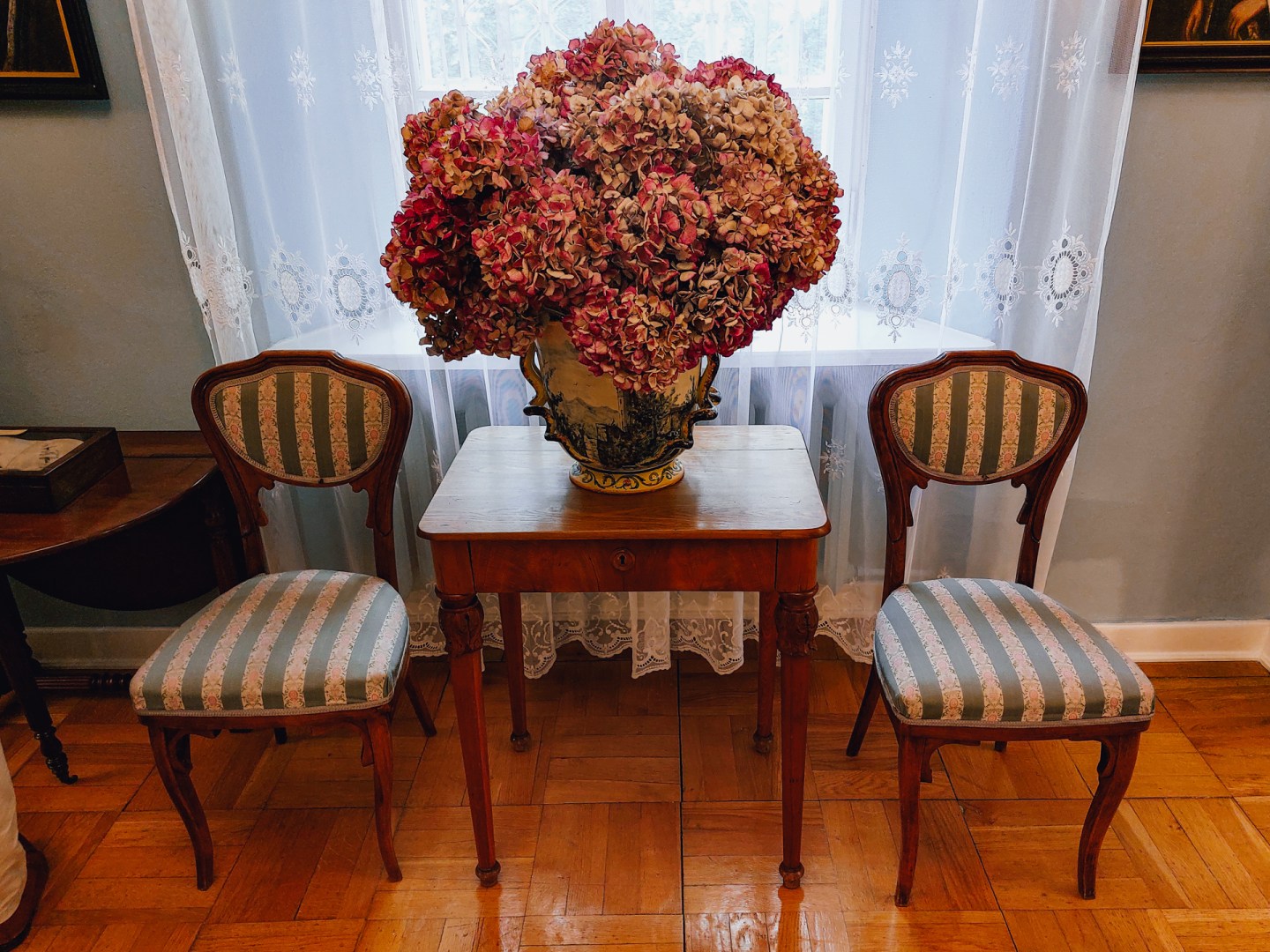 Dried floral arrangement and period chairs in the Walewski manor salon.