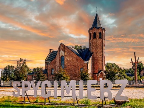 Church in Spycimierz at sunset with welcome sign