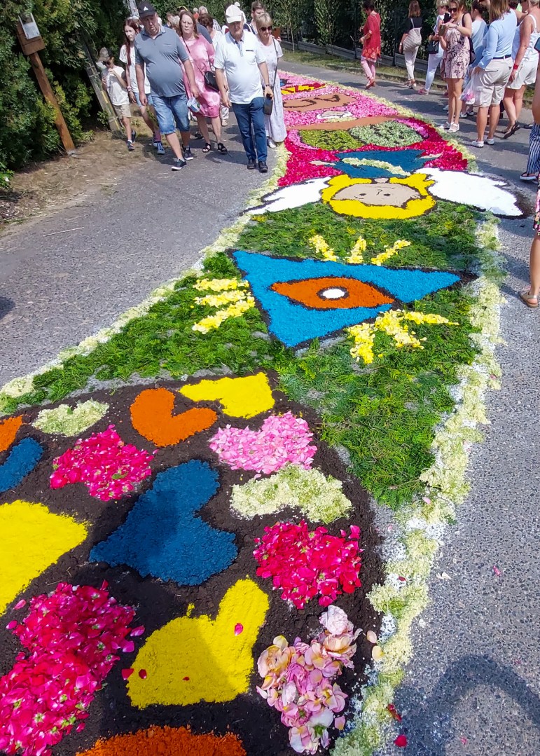 Colorful heart-themed flower carpet in Spycimierz during Corpus Christi 2024