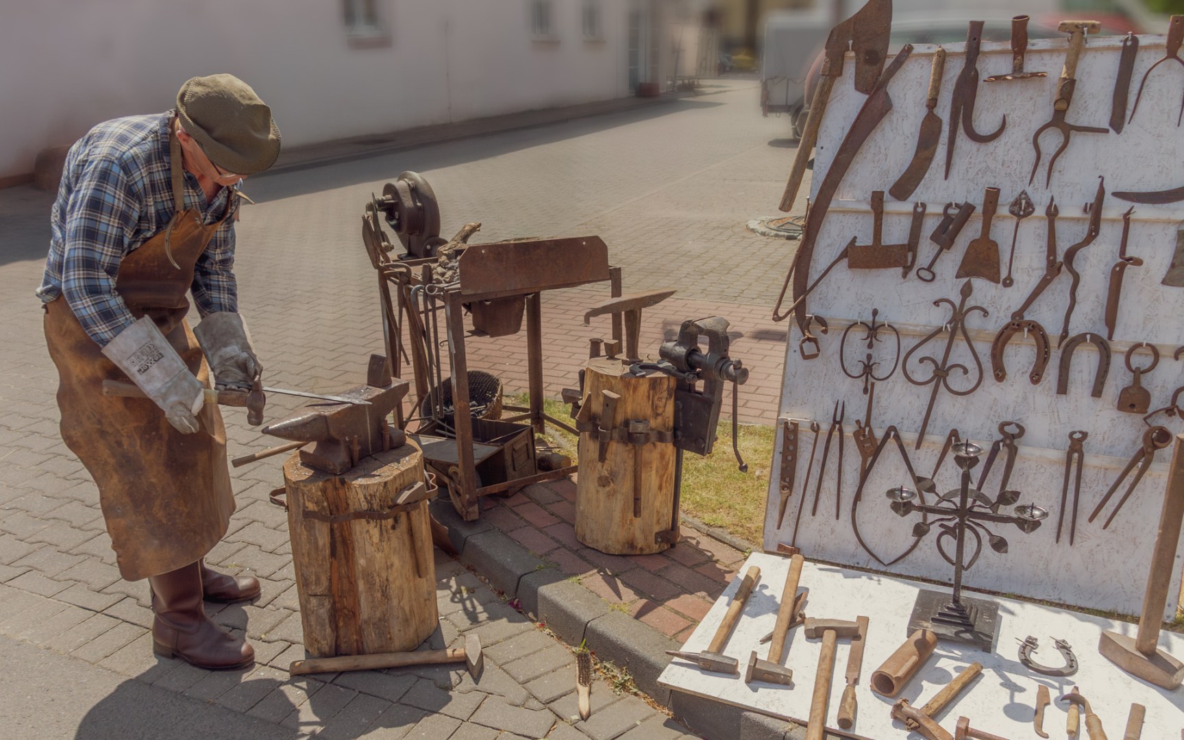 Man demonstrating traditional blacksmithing techniques with vintage tools during a 19th-century reenactment in Zduńska Wola