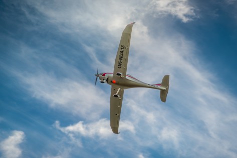 White aircraft rolling with blue sky and clouds in background