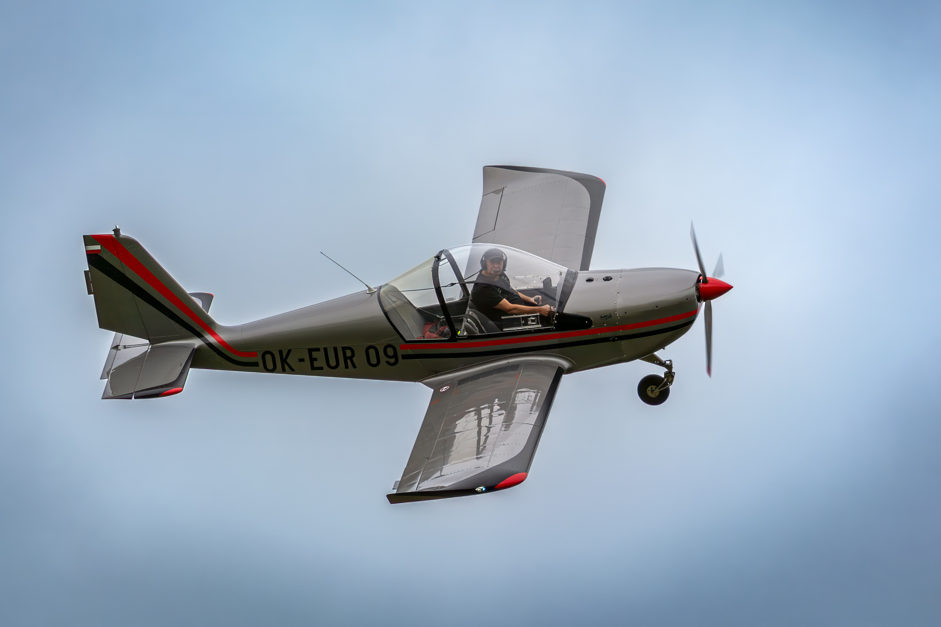 Small vintage aircraft flying against a light blue sky