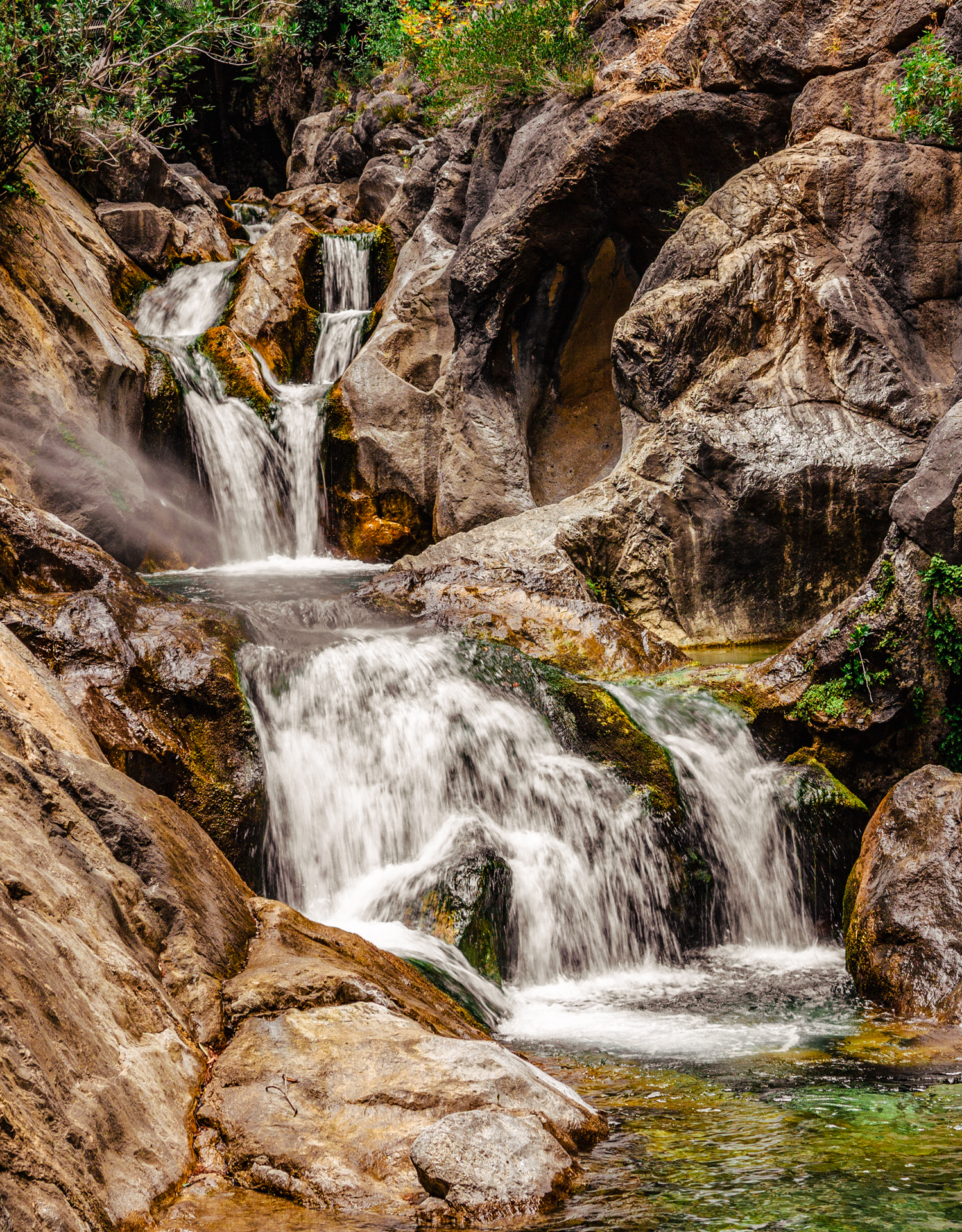 Twin waterfalls flowing through rocks into shallow pools in Sapadere Canyon