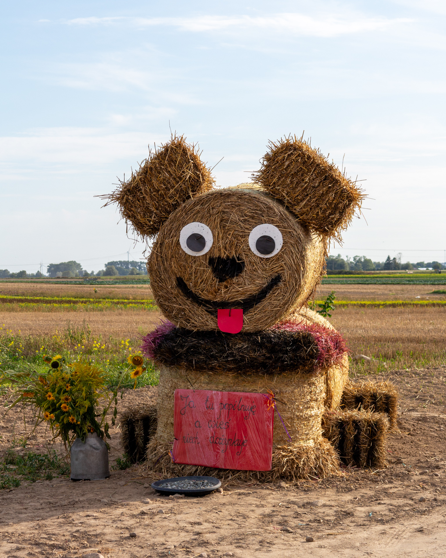 Hay bale dog sculpture with big ears and tongue out
