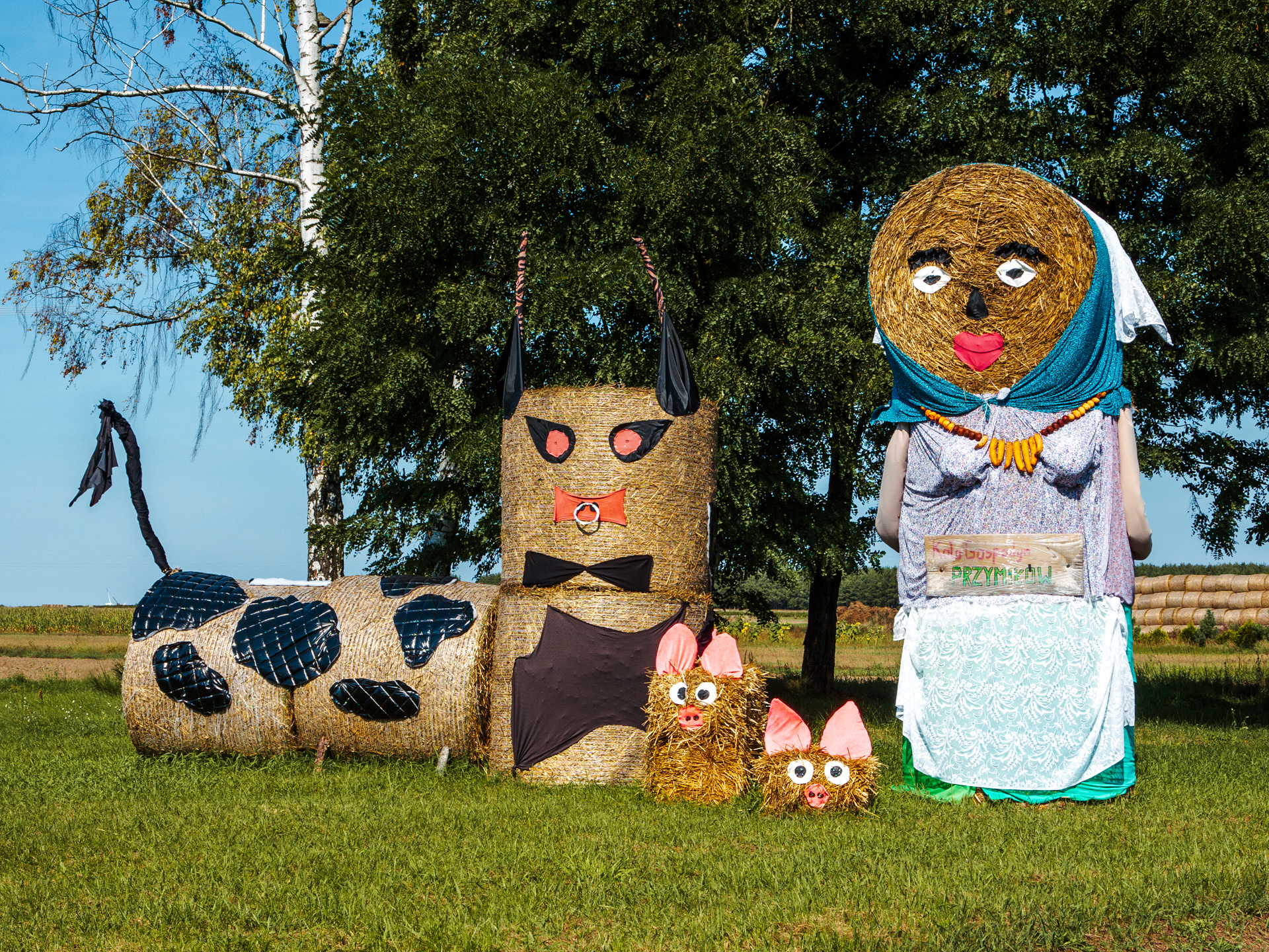 Hay bale nativity-style scene with sheep and figures at Polish festival
