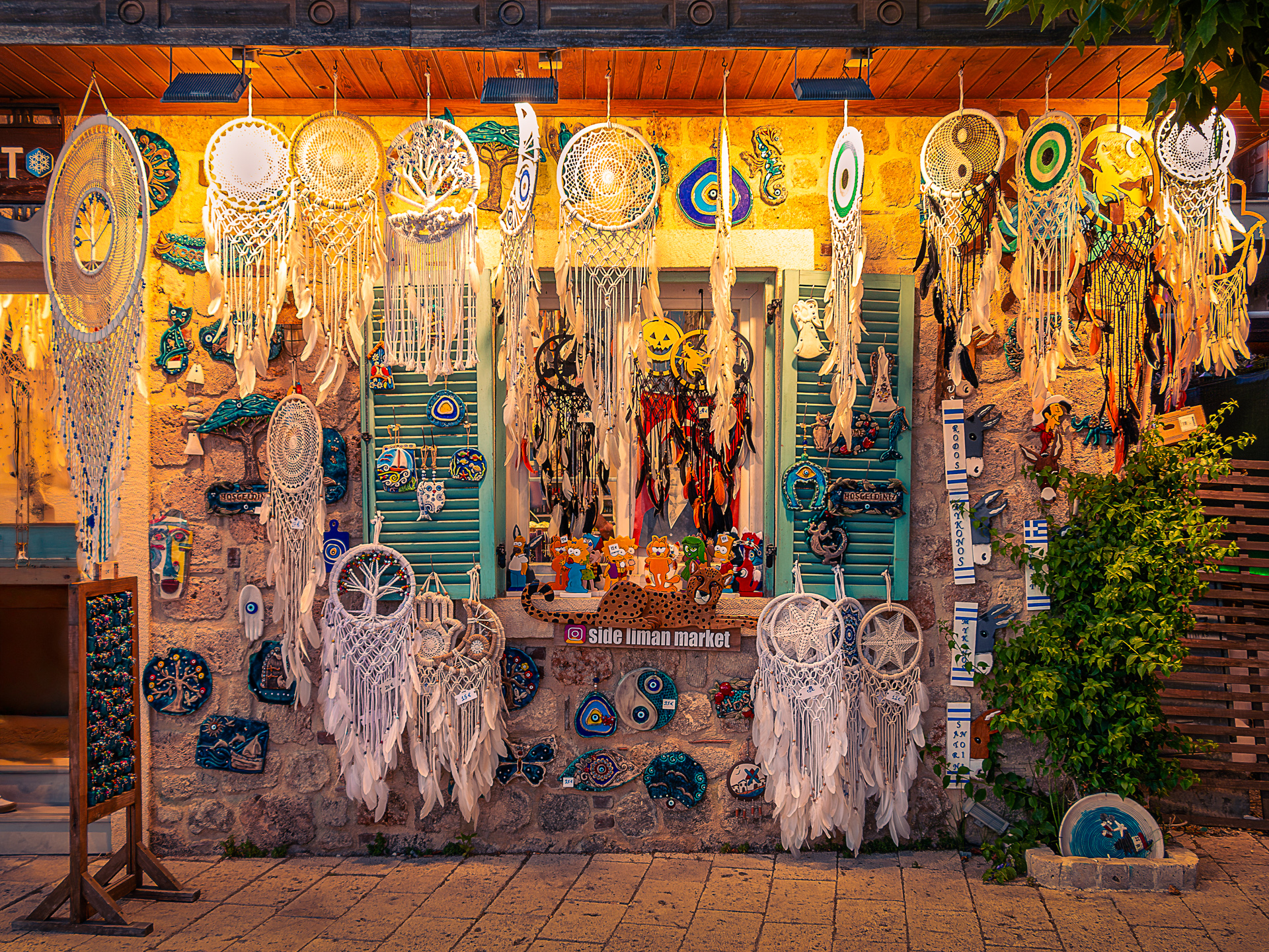 Colorful Mediterranean shop in Turkey with dreamcatchers and turquoise shutters glowing in evening light