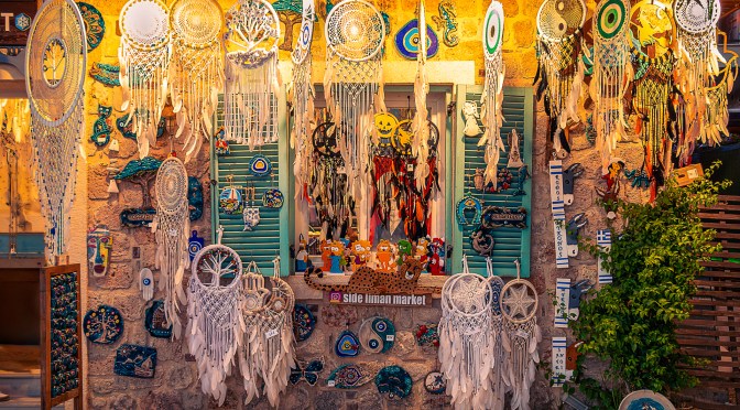 Colorful Mediterranean shop in Turkey with dreamcatchers and turquoise shutters glowing in evening light