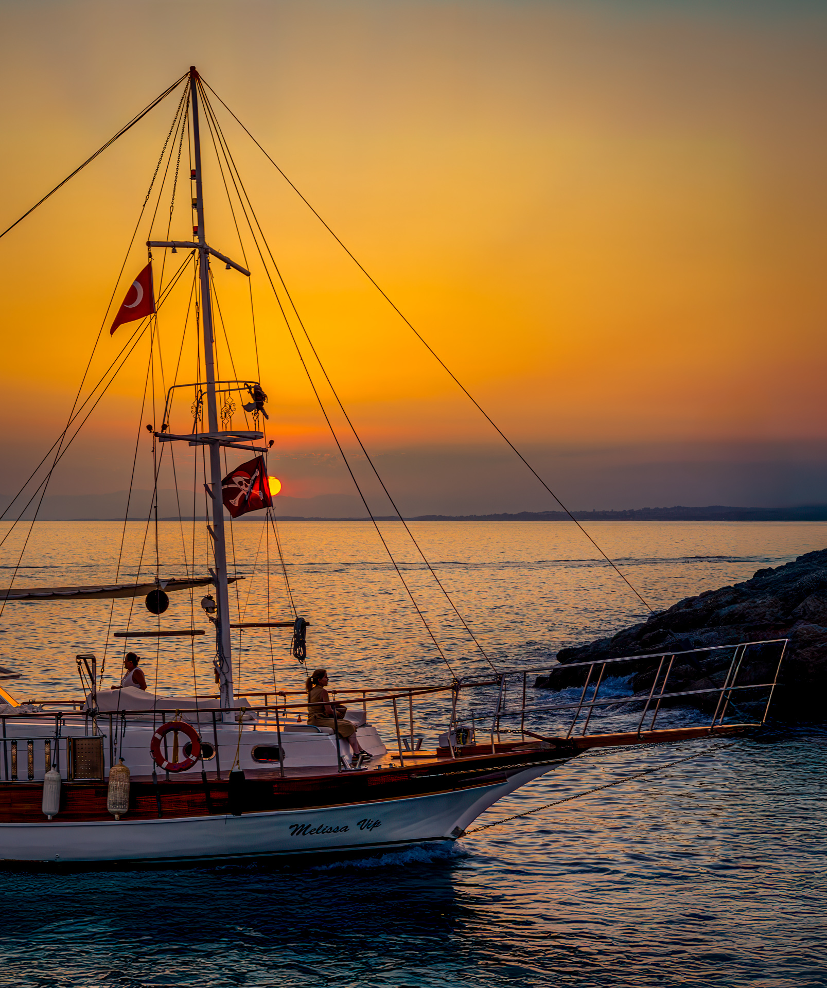 Sailing boat with Turkish flags at sunset on the Mediterranean Sea