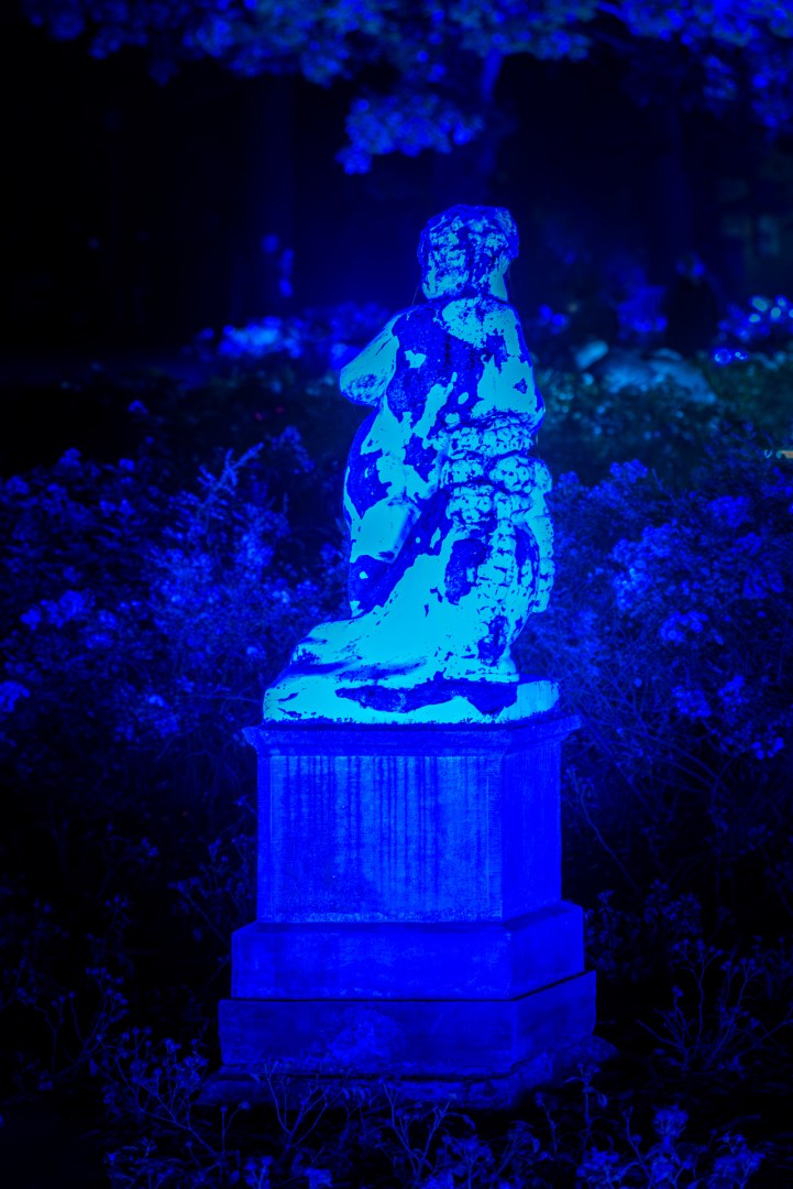 Statue bathed in deep blue light during the Light Move Festival 2025 in Łódź