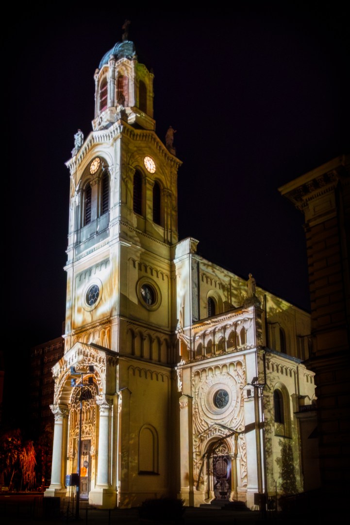 Church tower lit with warm golden tones during Light Move Festival 2025 in Łódź