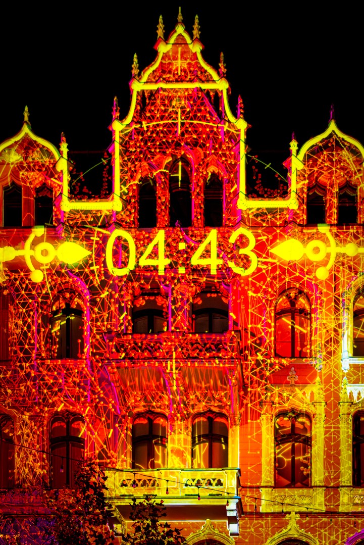 Golden projection with digital clock display on a building during Light Move Festival 2025 in Łódź