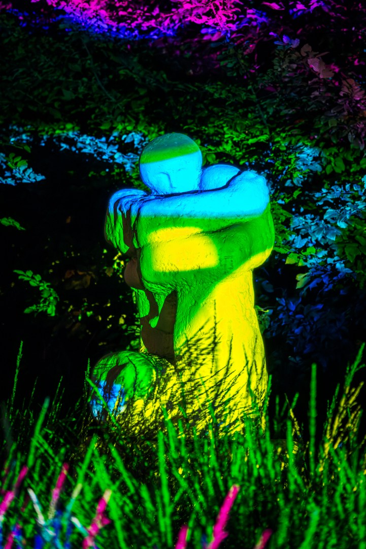 Abstract green and blue light installation illuminating a garden sculpture at Light Move Festival 2025