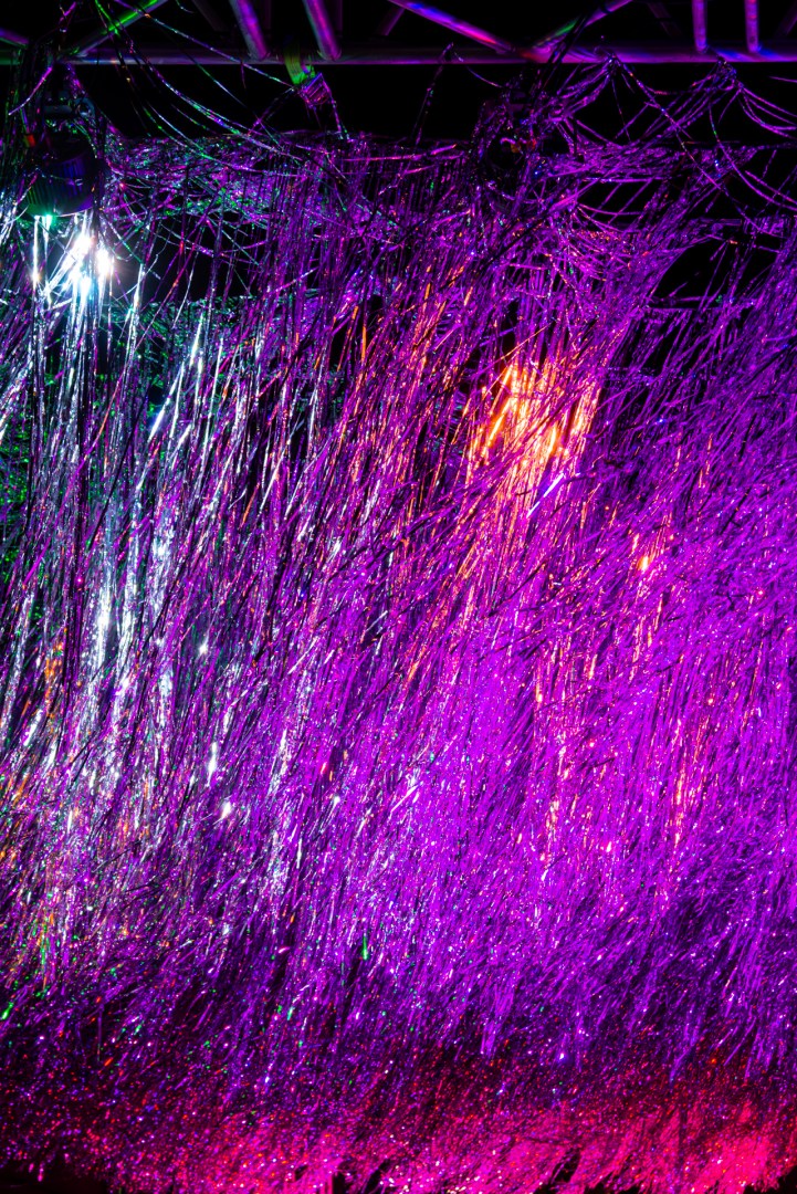 Purple and magenta light art installation resembling falling rain during Light Move Festival 2025