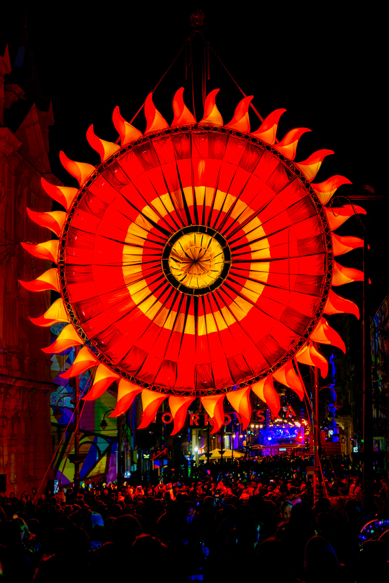 Sun-themed light projection in vivid red and orange during Light Move Festival 2025