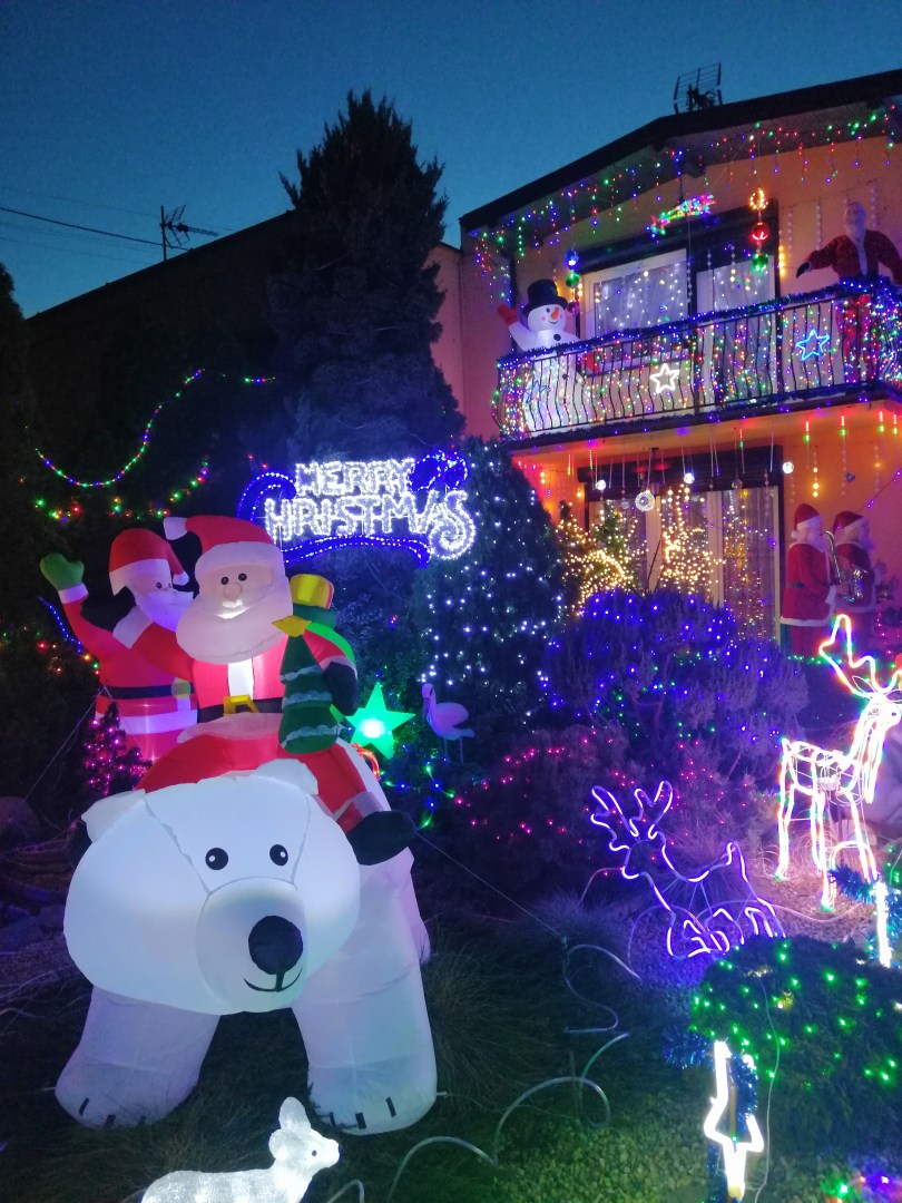 Illuminated house with Santa Claus figure and Merry Christmas sign at Polish Las Vegas