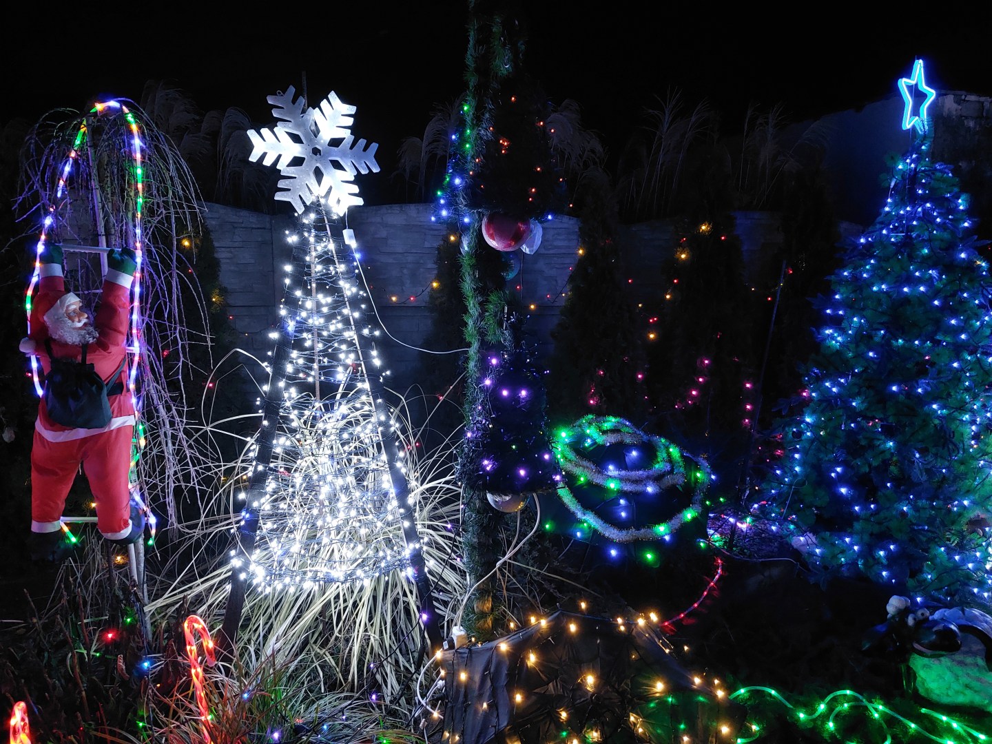 Illuminated trees with a Santa Claus figure appearing to escape through the lights